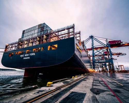 A large cargo ship docked at Gothenburg port with industrial cranes, Sweden.
